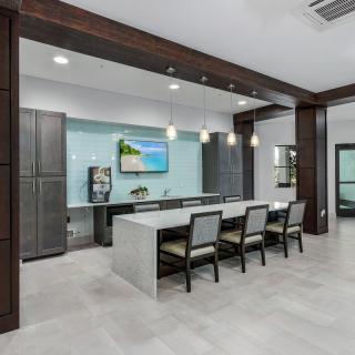 A modern kitchen with a large island, sleek cabinetry, and pendant lighting in an open floor plan.