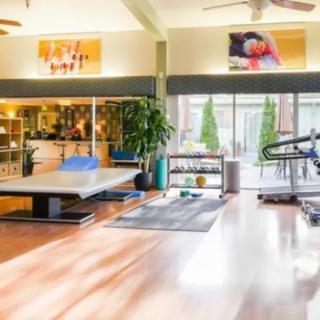 A modern gym interior with various exercise equipment and bright lighting.