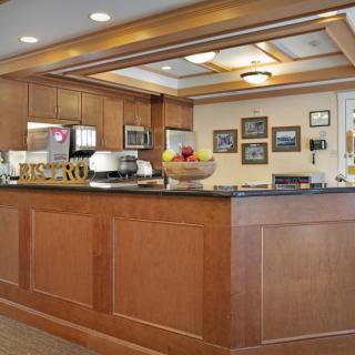 A well-lit reception area featuring a wooden desk with decor and framed artwork on the walls.