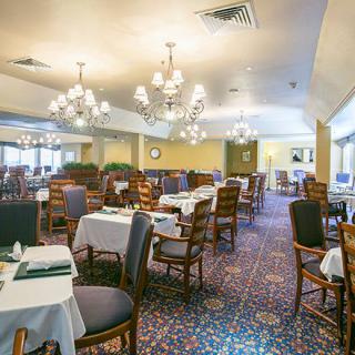 Elegant dining area with neatly arranged tables and classic chandeliers.