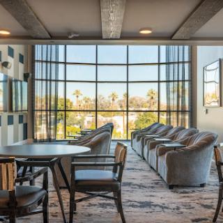 A contemporary lounge area featuring comfortable seating and large windows that let in ample natural light.