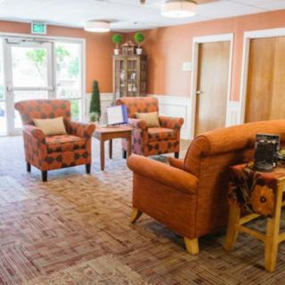 A cozy waiting room with comfortable armchairs and warm decor.