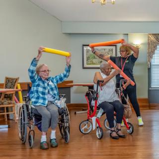 Seniors engaging in a fun exercise class using foam rollers for physical activity and rehabilitation.