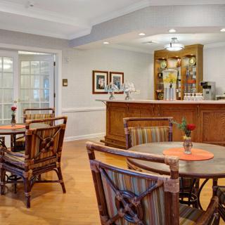 A cozy dining area with wooden tables, chairs, and a bar counter.