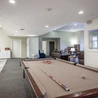 A spacious game room featuring a pool table and comfortable seating for relaxation.