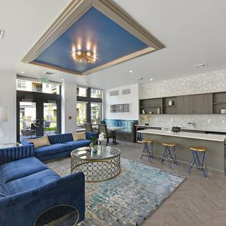 A modern, open-concept living room featuring a blue color scheme and luxury decor.
