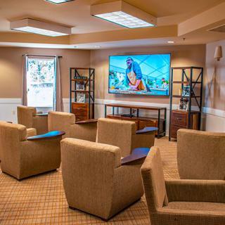 A cozy lounge area with comfortable seating and a large television.