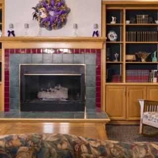 A cozy living room featuring a fireplace and bookshelves adorned with decor.