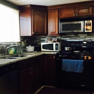 A cozy kitchen with dark wooden cabinets and modern appliances.
