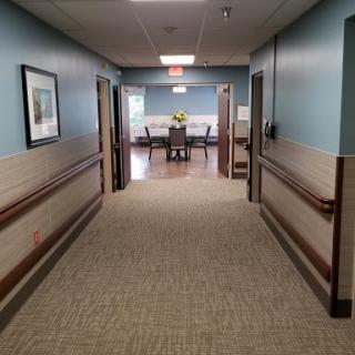 A view of a well-lit hallway leading to a waiting area in a healthcare facility.