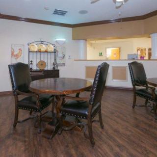 A cozy dining area with wooden tables and chairs, featuring elegant decor and warm lighting.