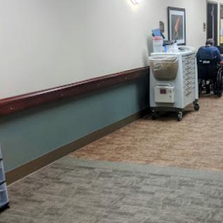 A view of a hospital hallway featuring medical equipment and seating.