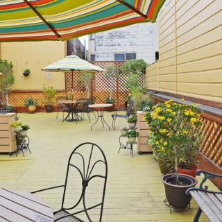 A cozy patio with colorful umbrellas and potted plants, perfect for outdoor relaxation.