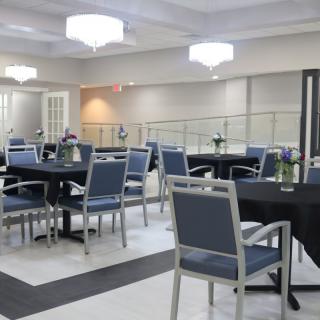 A modern dining area with neatly arranged tables and chairs under elegant lighting.