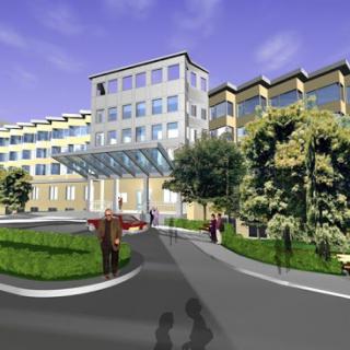 A modern hospital building with a landscaped entrance, featuring greenery and a welcoming pathway.