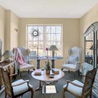 A cozy living room with elegant furniture and ample natural light streaming through large windows.