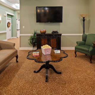 A cozy living room setup with a sofa, armchair, coffee table, and television.