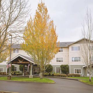 A hotel building with autumn trees in front.