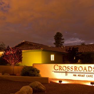 Night view of a building with illuminated sign reading 'Crossroads Adult Care'.