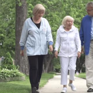 A group of people walking together on a tree-lined sidewalk.