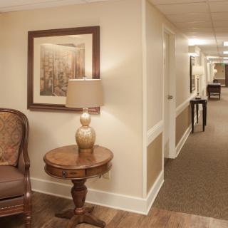 A warmly lit hallway with elegant furnishings and artwork on the walls.