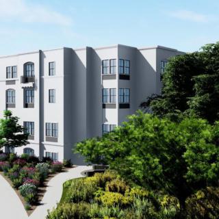 A modern apartment building surrounded by lush greenery.