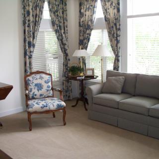 Elegantly decorated living room with a comfortable couch and floral armchair.