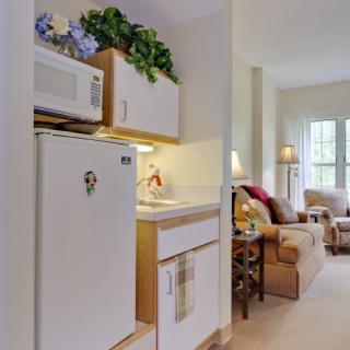 A cozy apartment with a small kitchenette and a comfortable living area.