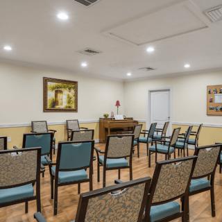 An empty meeting room with rows of chairs arranged for a gathering.