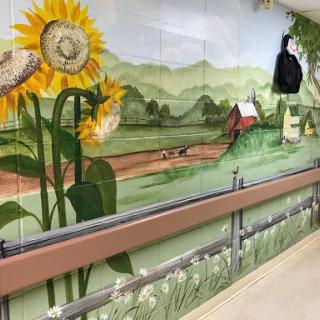 A vibrant mural depicting sunflowers and a serene countryside landscape.