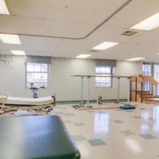 A spacious rehabilitation room equipped for physical therapy sessions.