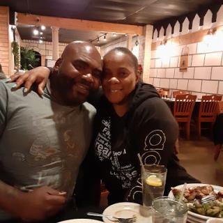 A joyful couple enjoying dinner together at a cozy restaurant.