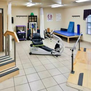 A well-equipped physical therapy room with various rehabilitation equipment.