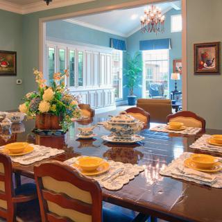 A beautifully set dining room with elegant decor and a view into a bright, inviting living space.
