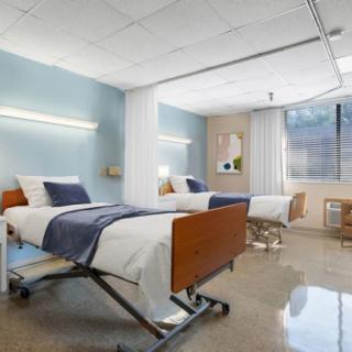 A clean and modern hospital room with two beds.