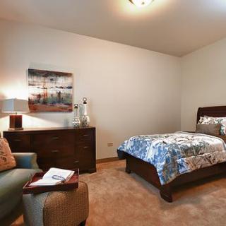 A cozy bedroom with a single bed, a dresser, and stylish decor.
