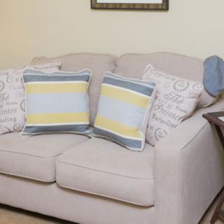 A cozy living room sofa adorned with patterned and striped cushions.
