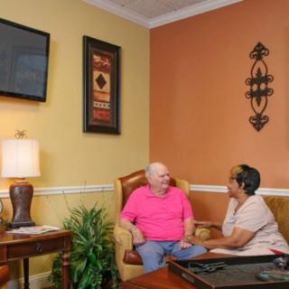 Two people sitting and conversing in a cozy living room.
