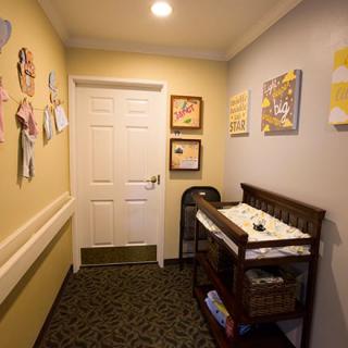 A cozy baby changing area with a decorated wall and essentials.