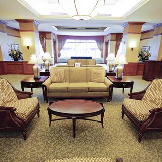 A luxurious hotel lobby featuring elegant seating arrangements with sofas, armchairs, and a coffee table.