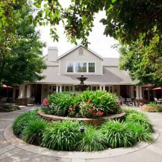 A charming house surrounded by a beautifully landscaped garden and trees.
