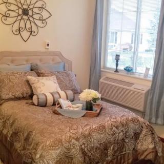 A cozy bedroom with elegant decor and a neatly arranged bed.