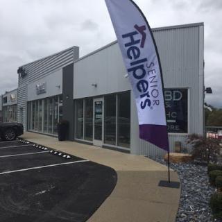Exterior view of a senior care service storefront with promotional flag.