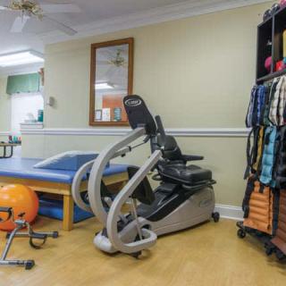 A rehabilitation room equipped with various exercise machines and therapy tools.