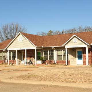 A suburban house with a red roof under a clear blue sky.