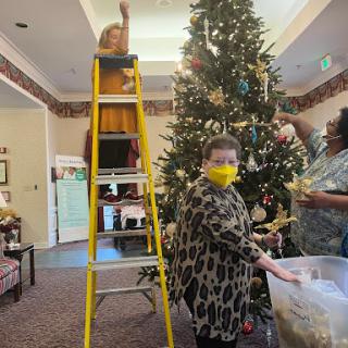 A joyful moment spent decorating a Christmas tree, bringing together family and community spirit.