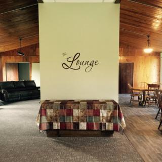 A cozy lounge area with a patchwork-covered couch and wooden furniture.