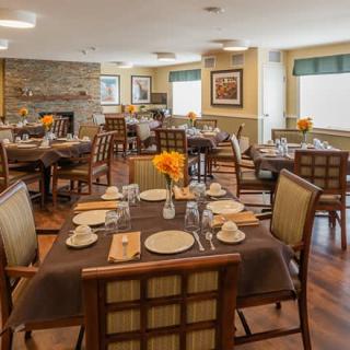 A cozy dining room interior with neatly set tables and comfortable chairs.