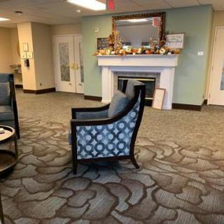 A cozy lobby area with a patterned chair and a decorated fireplace.