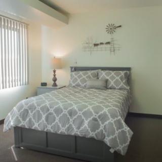 A cozy bedroom with a patterned bedspread and modern decor.